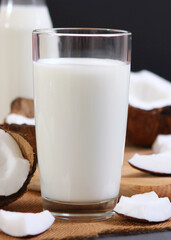 Milk and broken coconuts on the table. Vegetable milk, a veggie drink.. Vertical photo format
