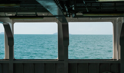 Ocean view through ship windows with distant islands and calm horizon, maritime travel