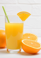 Orange juice in a glass, oranges and orange slices on the table.. Vertical photo format