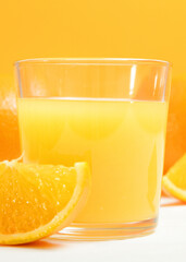 Orange juice in a glass, oranges and orange slices on the table.. Vertical photo format