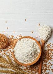 Wheat flour and spikelets of wheat on a light background. Vertical photo format
