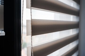Roller blind chain mechanism and zebra fabric texture in bright natural light © Volodymyr_sh