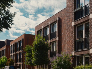 Contemporary residential architecture with balconies surrounded by mature trees and garden vegetation
