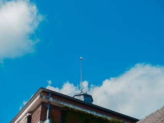 Historic building corner with ornamental cupola tower photographed from below against blue sky