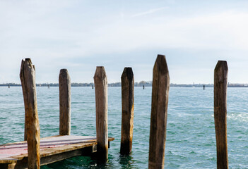 Serene lake pier scene with wooden posts and calm water