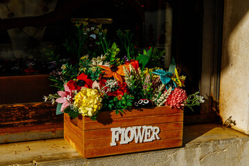 Rustic flower box with colorful bouquet on sunlit window ledge