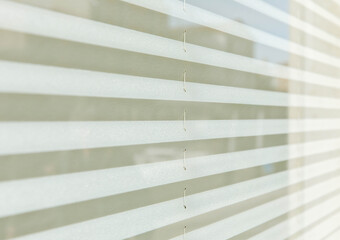 Horizontal white blinds with soft light and shadow patterns