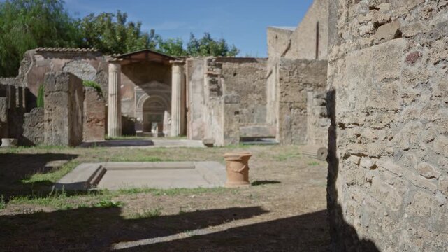 Pompeii ruins with soft defocused courtyard and textured stone wall in foreground, outdoor background; background backplate copyspace calm.