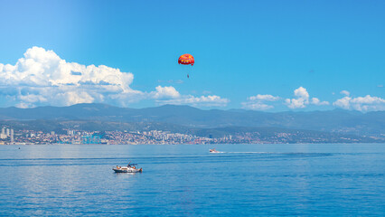 Parasailing Over the Sea with Mountain View on Sunny Day