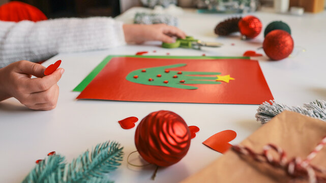 Child's handprint Christmas tree craft on red paper with decorations - Powered by Adobe
