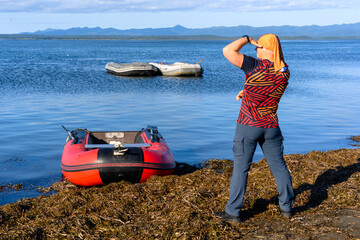 Person enjoying a sunny day by the water while gazing at distant boats in the calm sea