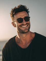 Obraz premium portrait of handsome young man wearing sunglasses and looking at camera portrait of joyful man enjoying summer holiday at beach young casual man in shades with big grin and copy space no logos no bra