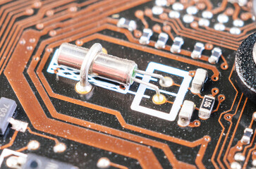 Quartz crystal resonator on old motherboard close up showing vintage computer electronics macro detail