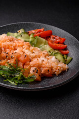 A food bowl with salmon, rice, avocado, tomatoes, and cucumbers. A salmon bowl