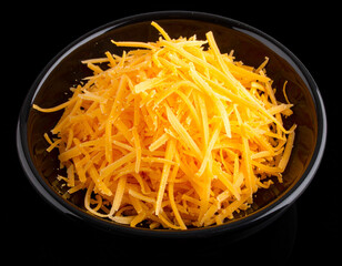 A bowl of grated cheese isolated on a black background
