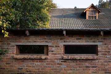 Old Brick Wall with Small Windows and Tiled Roof