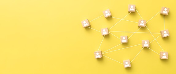 Wooden cubes with people icons connected by lines on yellow background connection