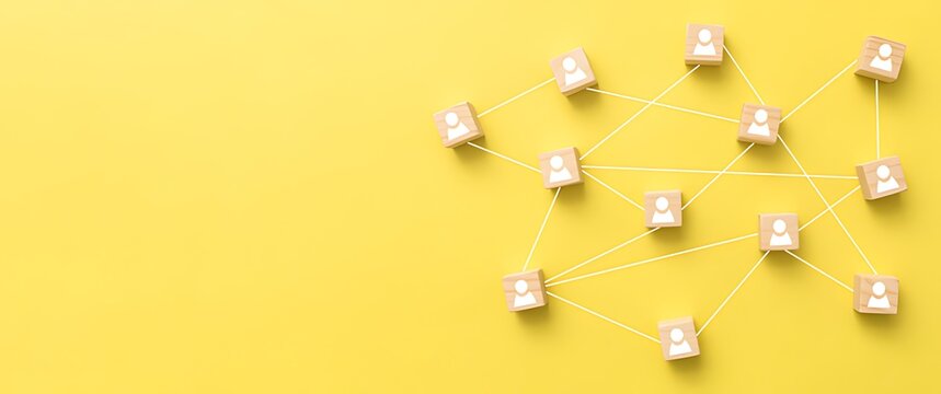 Wooden cubes with people icons connected by lines on yellow background connection