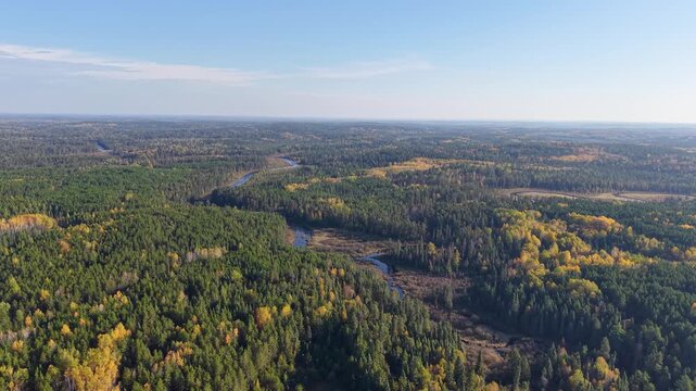 MINNESOTA - 10.31.2025 - Fantastic aerial footage approaching a long river snaking through an autumnal Minnesota forest.