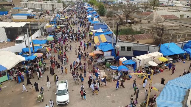 SENEGAL - 10.23.2025 - Fantastic aerial footage following a street packed with Muslim pilgrims as they approach the Great Mosque of Touba.