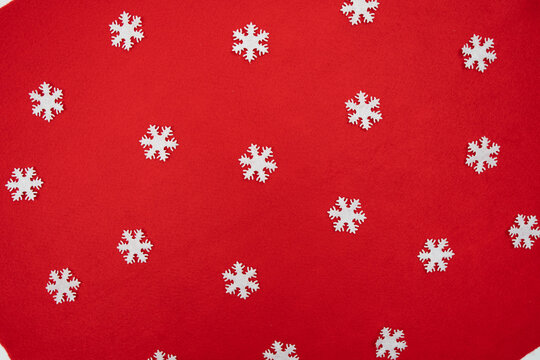 Seamless Christmas pattern with white snowflakes scattered evenly across vivid red textured surface perfect for wrapping paper backgrounds digital prints festive cards and seasonal visual projects