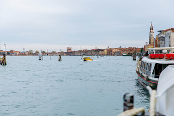 Murano, Italy - November 21, 2024: Scenic excursion to Murano Island showcasing vibrant boats on serene waters with historic architecture in the background, perfect for travel enthusiasts