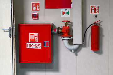 Red fire safety equipment on display in a public building hallway during daytime