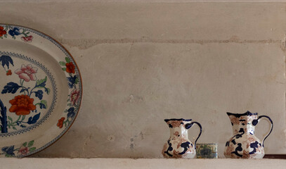 Ceramic decorative items on a shelf against a wall