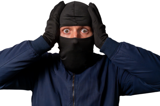 Thief wearing a balaclava and gloves looking shocked and afraid with hands on his head after getting caught