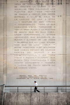 Guard walking in front of stone tablet in Mexico City.