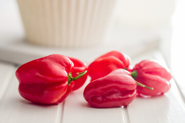 Red chili pepper habanero on white table.