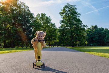 Child riding. Scooter toddler park play. Summer road motion casual sport.