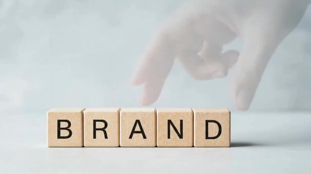 A hand places a wooden block to complete a word. The building process and letter display represent construction, strategy, project, name, and word