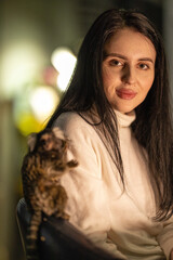 girl smiles while seated with her marmoset on her shoulder in a warm softly lit indoor space. The...