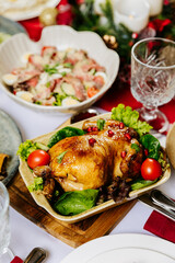 Roasted chicken with pomegranate and vegetables served on festive holiday table