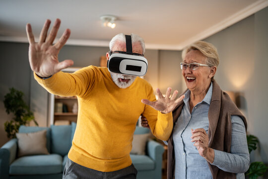 Senior man experiencing virtual reality with wife laughing