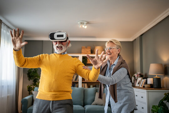Senior couple experiencing virtual reality headset fun at home