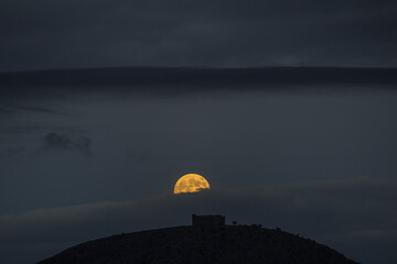 Obraz premium Supermoon Rising Behind Montgrí Castle in Catalonia, Spain. Full Beaver supermoon.