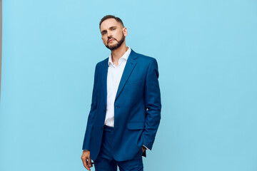 A composed business professional stands against a solid blue backdrop, projecting confidence and...