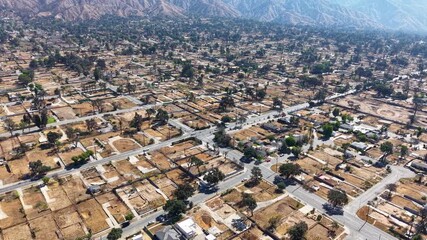 LOS ANGELES - 9.10.2025 - Aerial footage drawing back from the Altadena mountains to show a neighborhood in Los Angeles where every home has been eradicated by the Eaton wildfires.