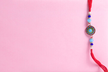 Delicate beaded bracelet with a round turquoise pendant on a pink background for gifting and fashion accessory.