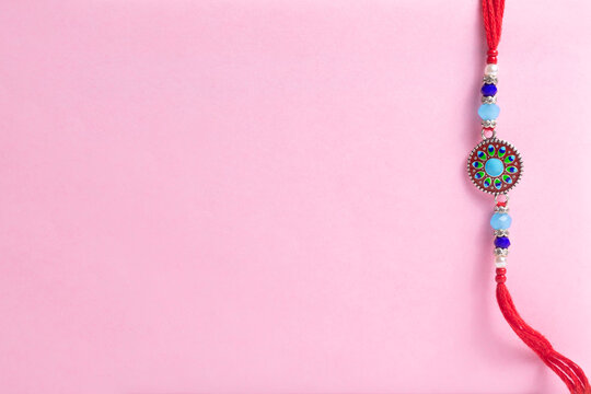 Delicate beaded bracelet with a round turquoise pendant on a pink background for gifting and fashion accessory.
