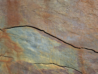 Natural brown stone texture with layered colors and cracks in a rocky surface