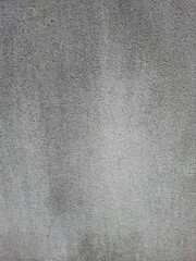 Gray concrete wall texture showing wear and weathering in an urban environment during daylight