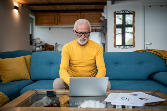 Senior man working from home using laptop