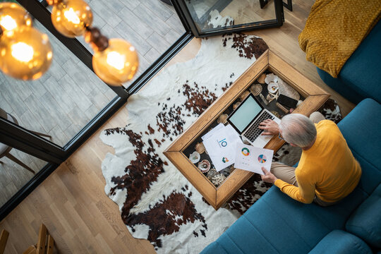 Senior man working from home checking financial charts