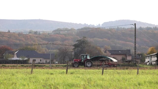 Un agriculteur passe la herse sur son terrain.