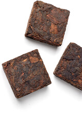 Black pu-erh Chinese tea. Pressed tiles of fermented black tea isolated on white background.
