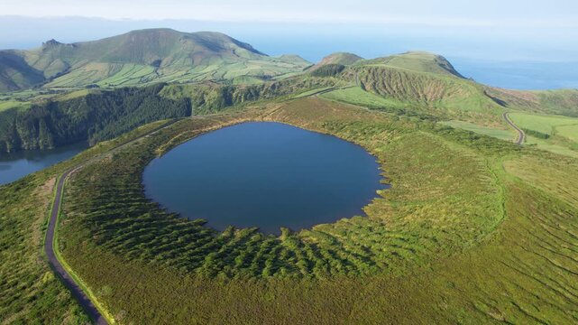 AZORES - 10.27.2025 - Excellent aerial footage circling counterclockwise around a clear blue volcanic lake surrounded by greenery on Flores Island.