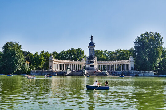 People and rowboats on Estanque lake in Parque del Buen Retiro with Monument to Alonso XII, Madrid, Spain, Europe